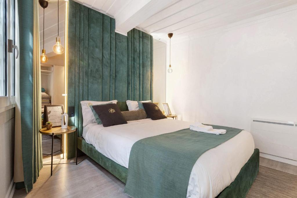 a bedroom with a large bed with a green headboard at Prestigegoldresidence 1 - Old Town in Guimarães