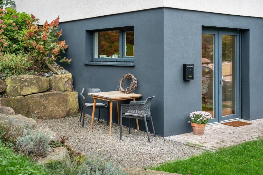 a table and chairs in front of a house at Fewo Kleines Glück in Friesenheim