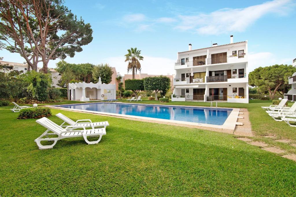 a villa with a swimming pool and a house at Mouramar Vilamoura in Vilamoura