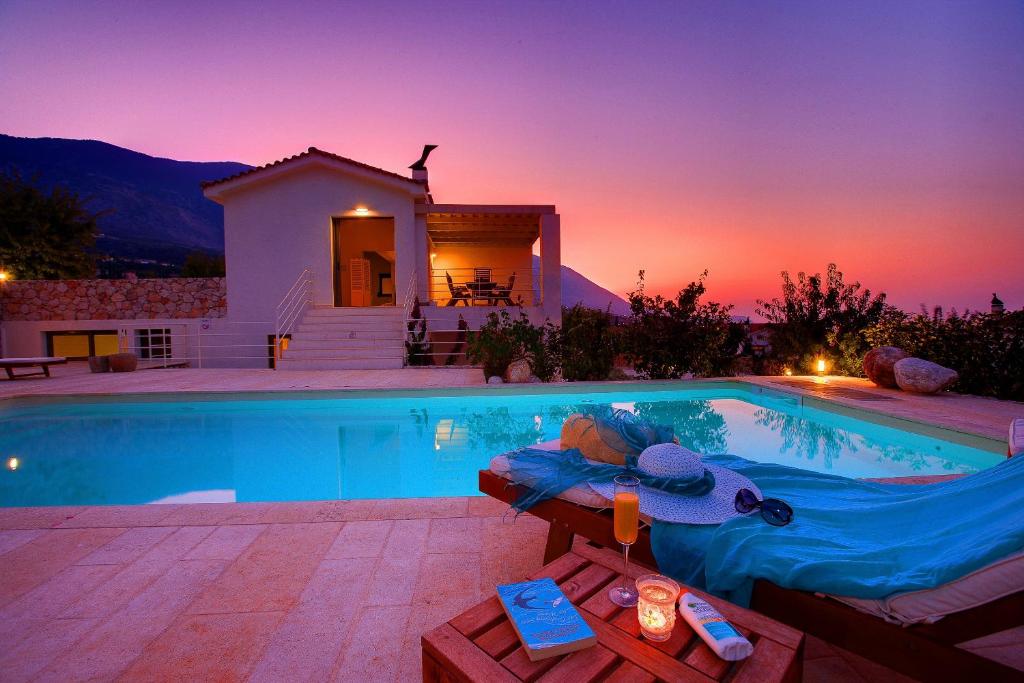 a swimming pool in front of a house at Villa Linatela Ideales Resort in Kefallonia