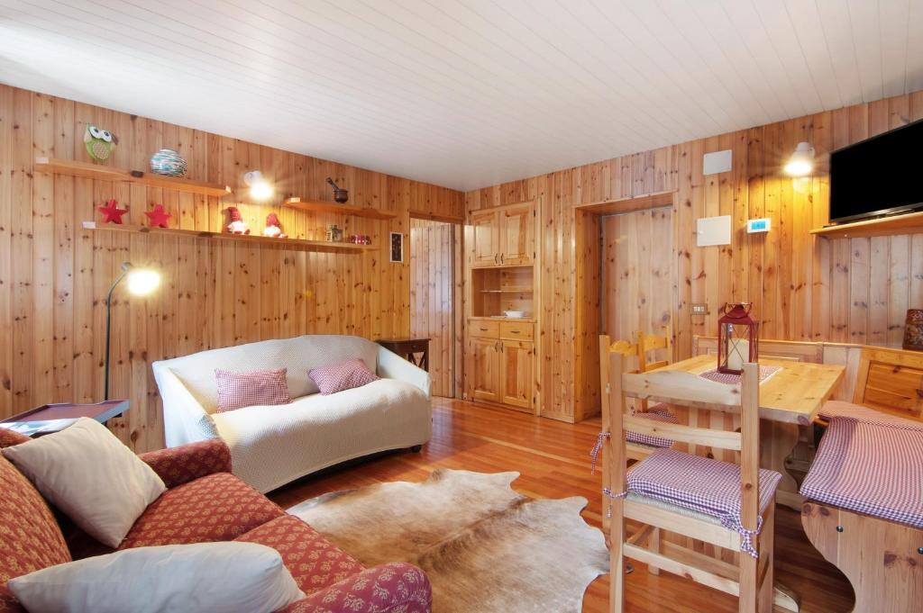 a living room with a couch and a table at Apartment Corti Garden in Campodolcino