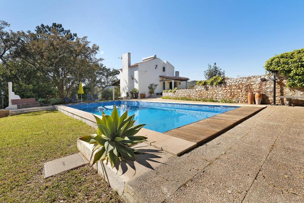 a swimming pool in front of a villa at Secluded House - Quinta La Rabide in Azeitao