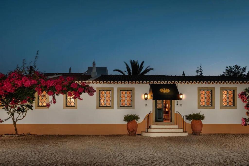 a white building with flowers in front of it at Liberal Wing Villa in Portimão