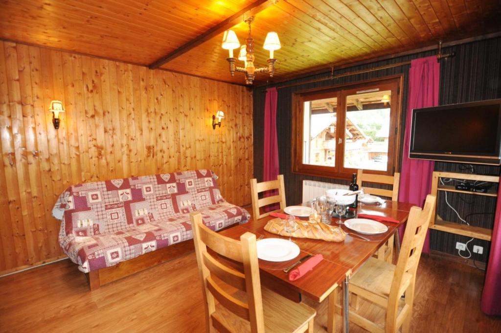 a dining room with a table and a couch at Le Mont de Grange in La Chapelle-dʼAbondance