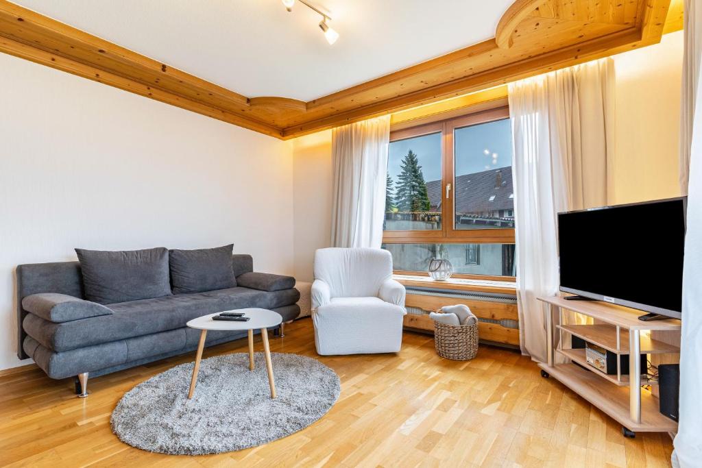 a living room with a couch and a tv at Fewo Schwarzwald - Haus Sommerberg in Baiersbronn