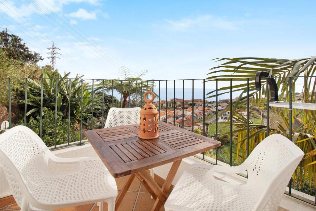 a wooden table and chairs on a balcony at Casa Amarela in Caniço