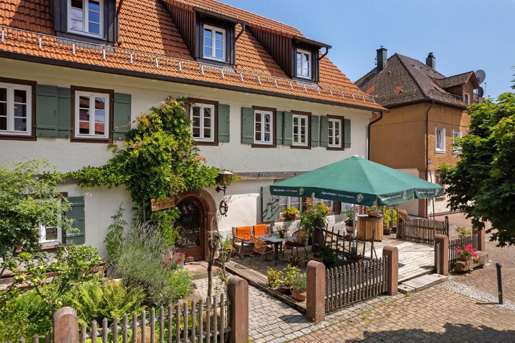 a house with a fence and a table and umbrella at Urlaub Im Kulturdenkmal in Alpirsbach