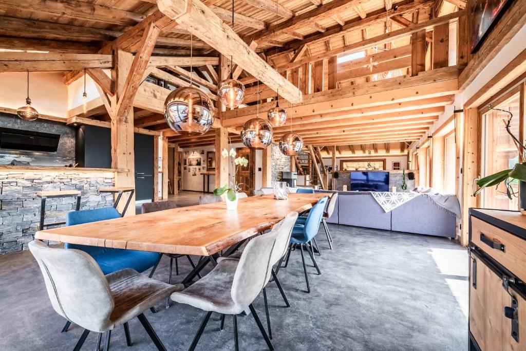 a large dining room with a wooden table and chairs at Le Perray Alpine Lodge in Abondance