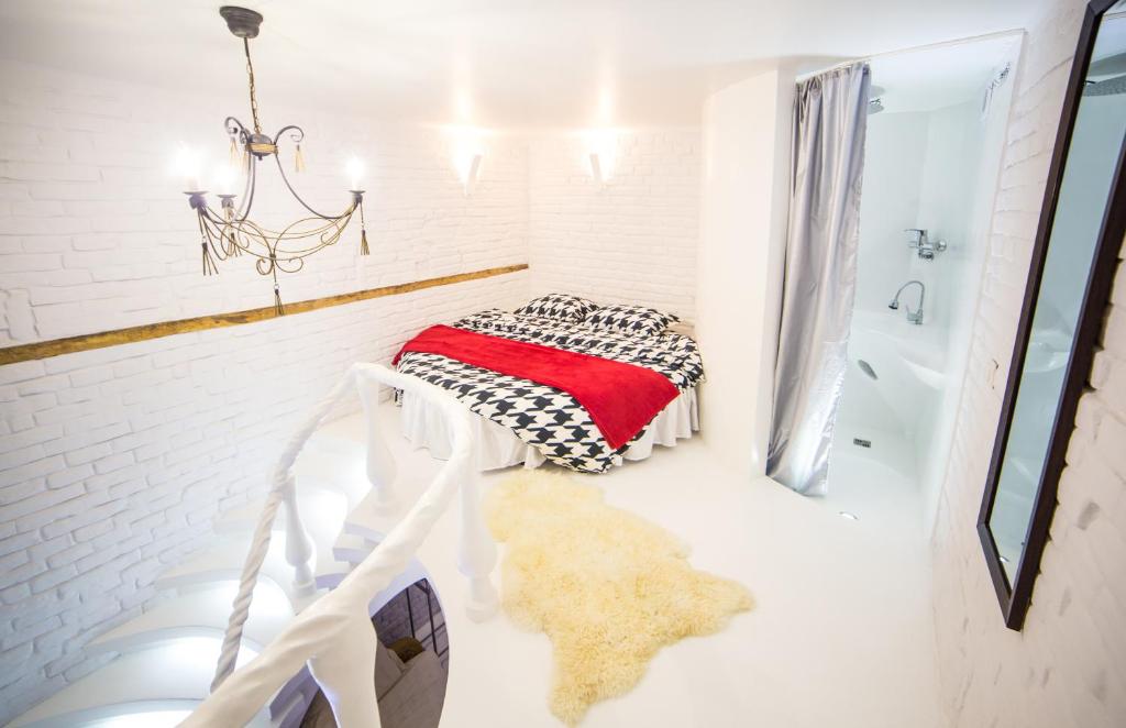 baño blanco con cama y bañera en Fabolous flat Art Design, en Leópolis