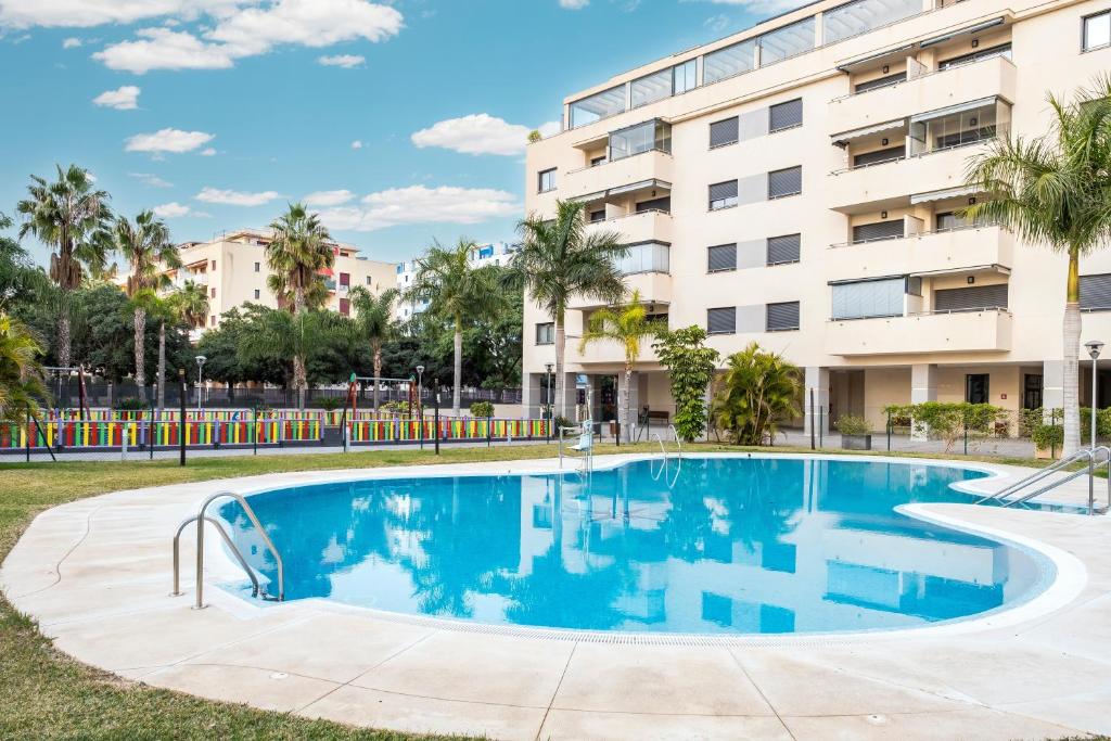 a swimming pool in front of a building at Playamarinsa in Torre del Mar