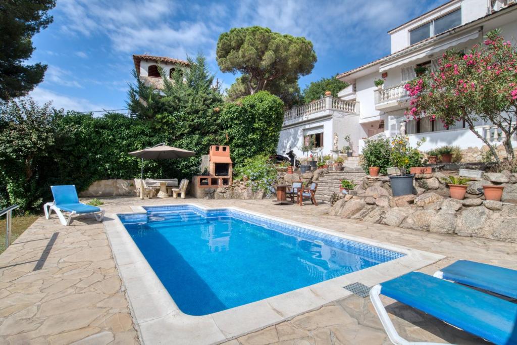 a swimming pool in front of a house at Casa Isabel in Calonge