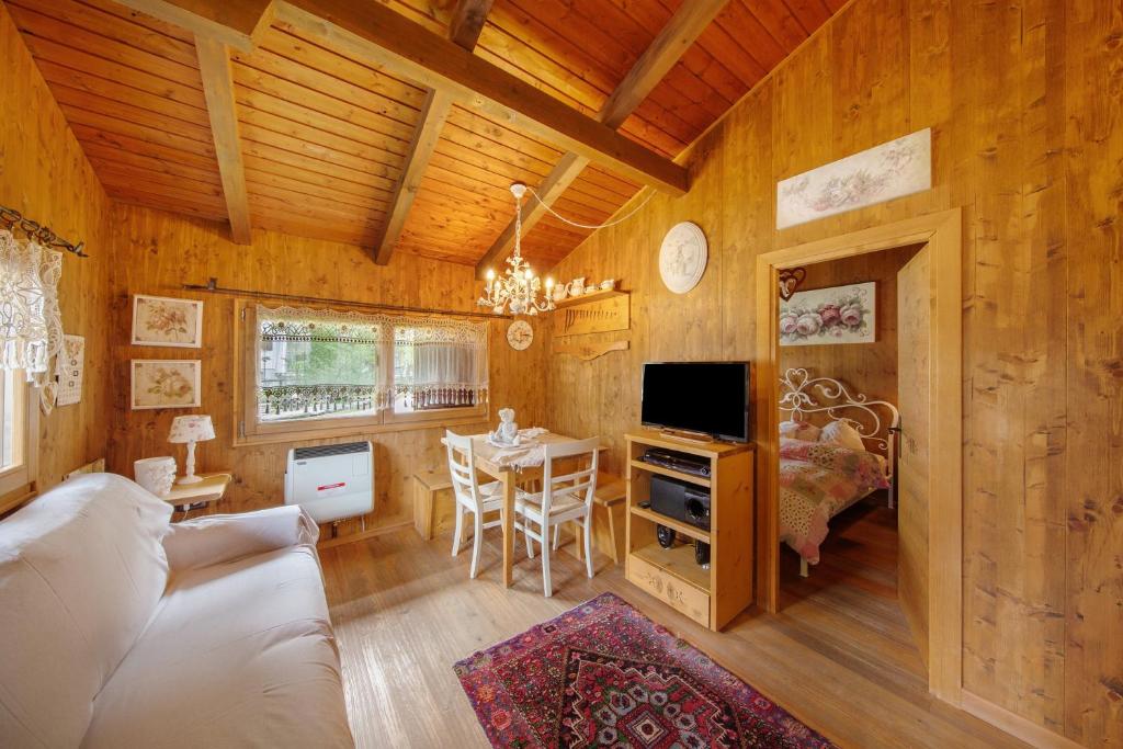 a living room with a couch and a table with a tv at Orserose Chalet 3 I Ciodi in Forno di Zoldo