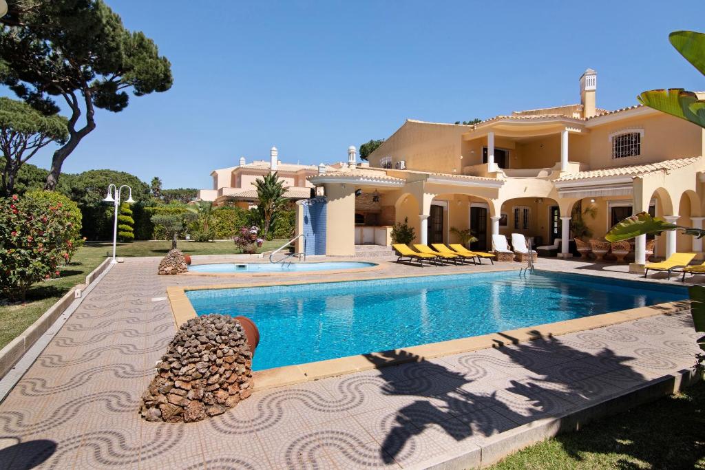 a large house with a swimming pool in front of it at V4 Galeão Vilamoura in Vilamoura