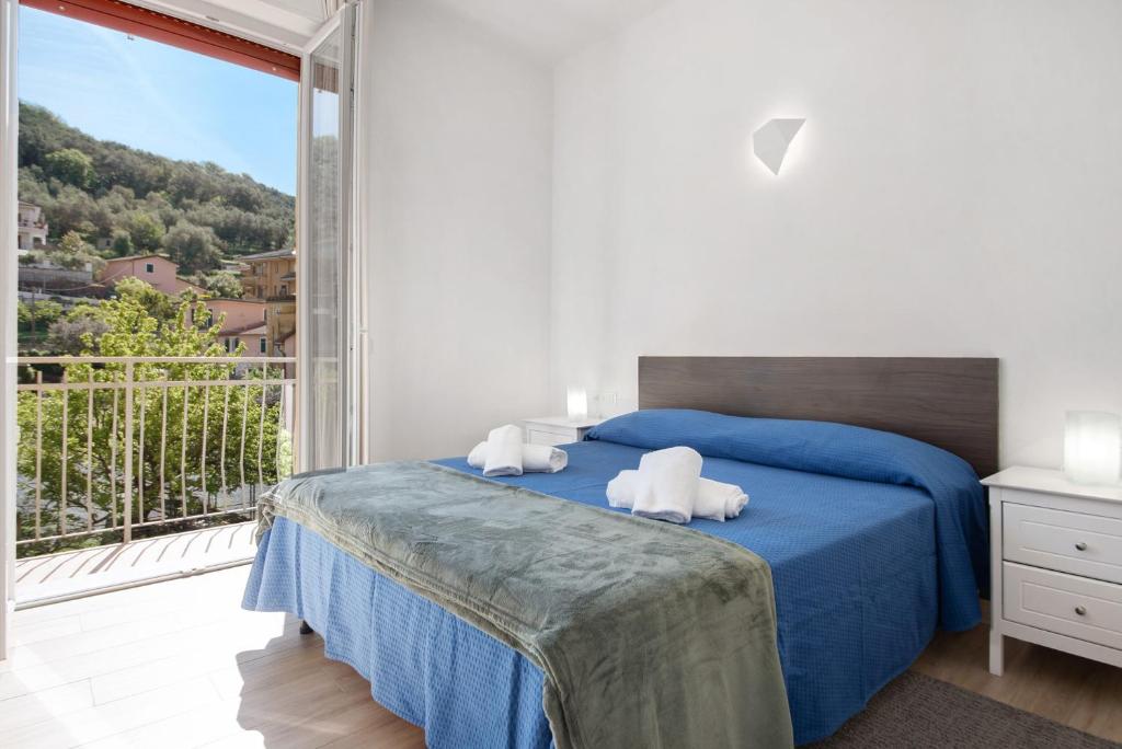 a bedroom with a blue bed and a large window at Moneglia Mare in Moneglia