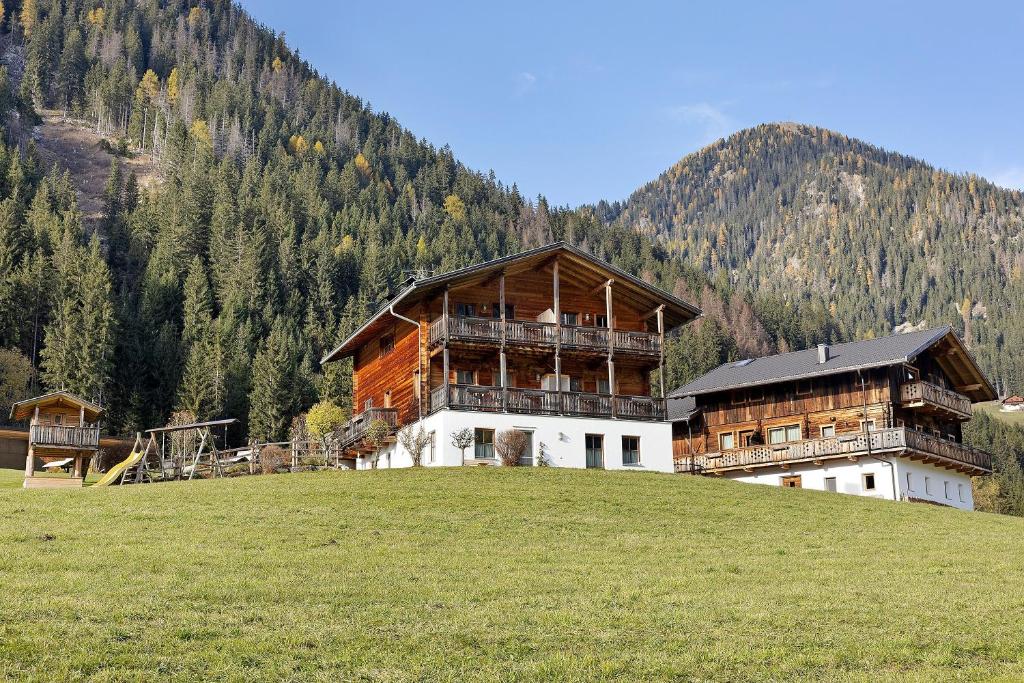 a large building on top of a hill with a mountain at Steineggerhof in Valle Di Casies