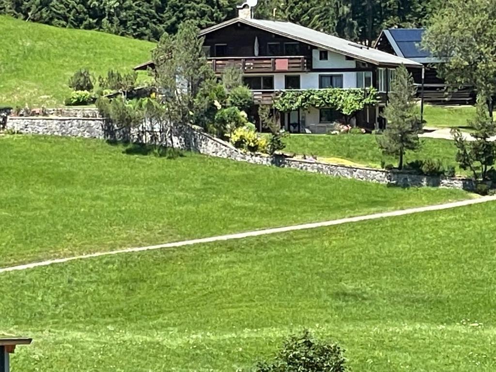 a house sitting on top of a green field at Fewo 2 am Auweg in Hirschegg