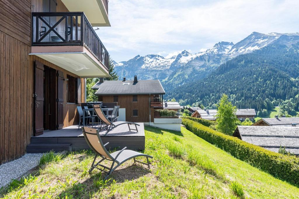 a house with two chairs on a balcony with mountains at victorsun2 in La Clusaz