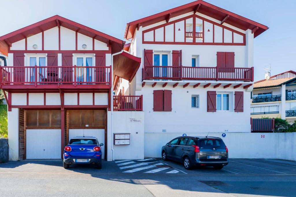 two cars parked in a parking lot in front of a building at Appartement Urrugne in Urrugne