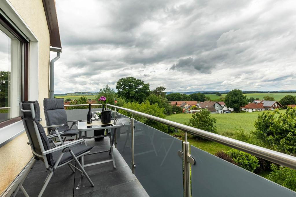 a balcony with a desk and chair on a balcony at Ferienwohnung Landblick in Homberg