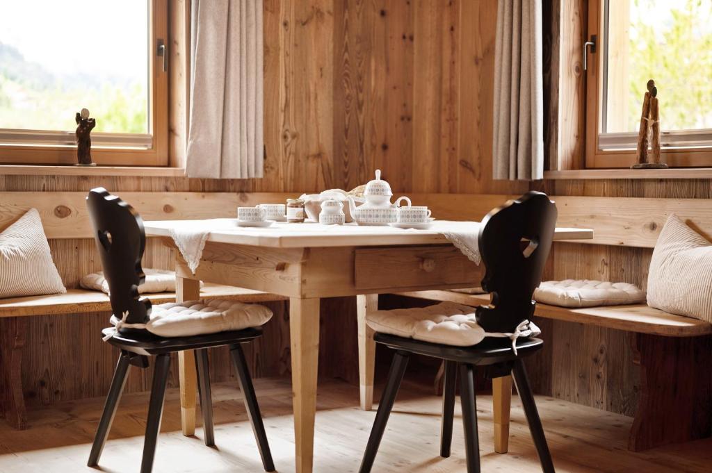 a wooden table with two chairs around it at Wellness Chalet Samer in Sarntal