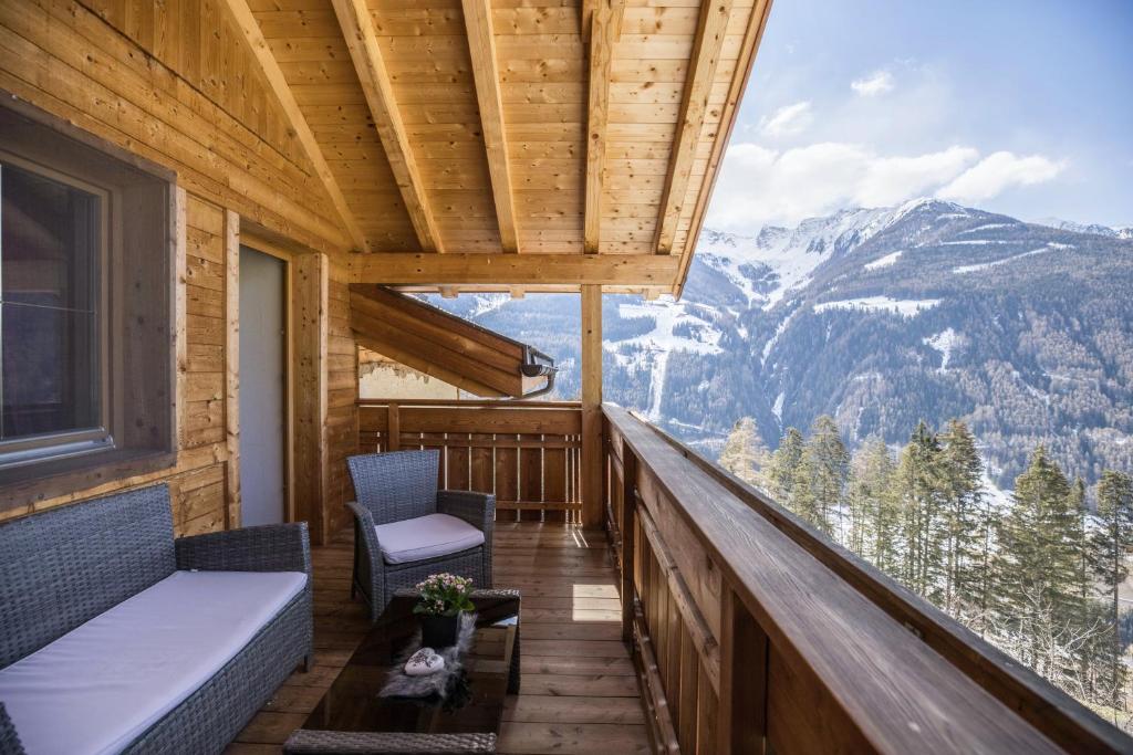 a balcony with chairs and a view of mountains at Golserhof Sonne in Cadipietra