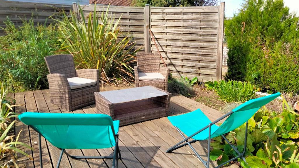 a patio with chairs and a table and a fence at Au Nid Douillet in Bourges