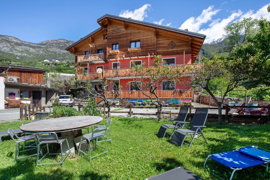 a table and chairs in front of a log house at Casa Michod - Nonno Marcel in Châtillon