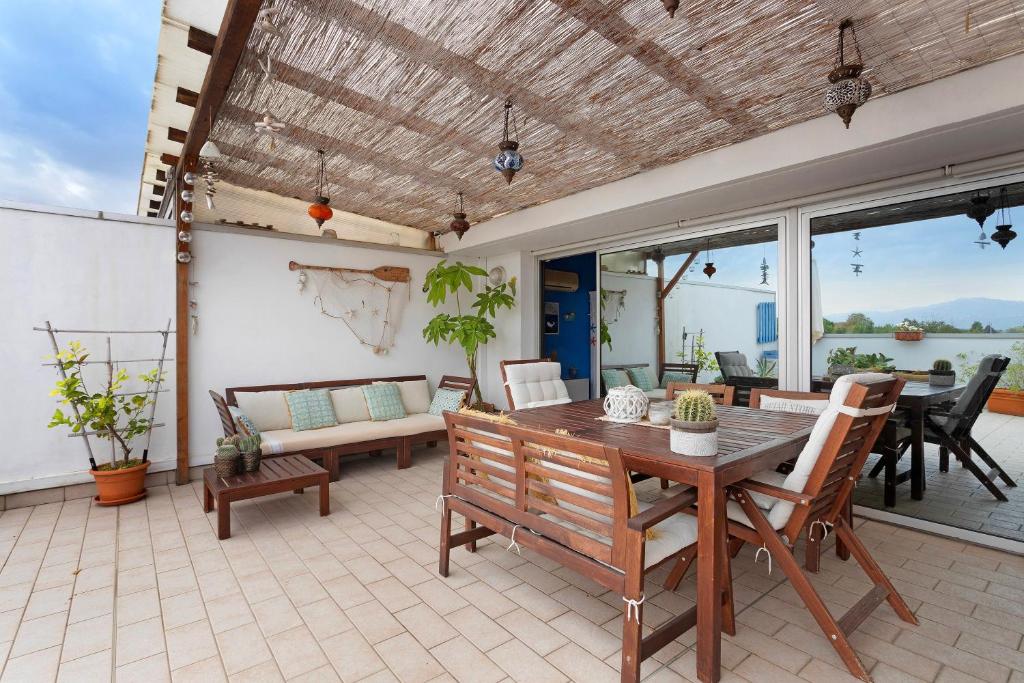 a patio with a wooden table and chairs at Attico con terrazza a Viareggio in Viareggio