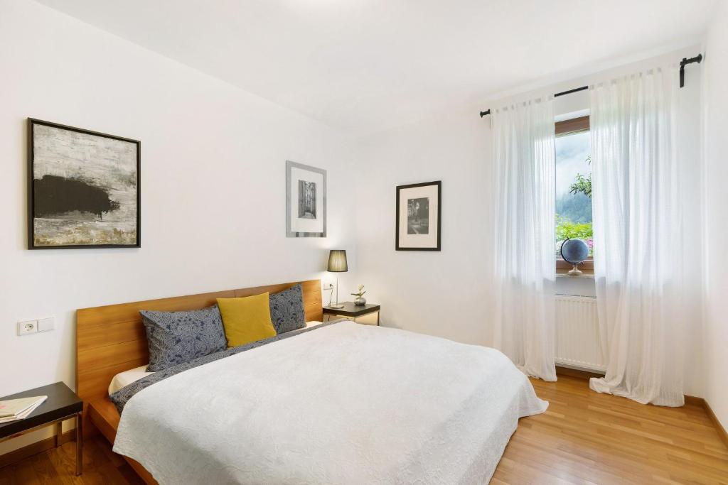 a white bedroom with a bed and a window at Kati´s Haus in San Pancrazio dʼUltimo