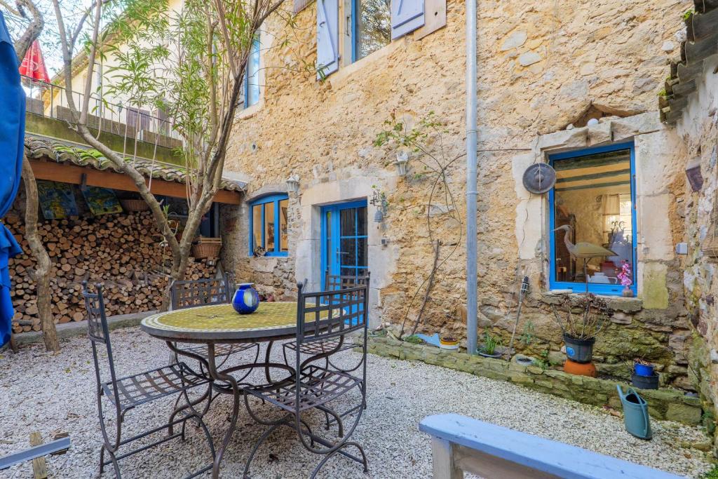 a patio with a table and chairs in front of a building at Laho - Chambre d'hôte in Lagorce