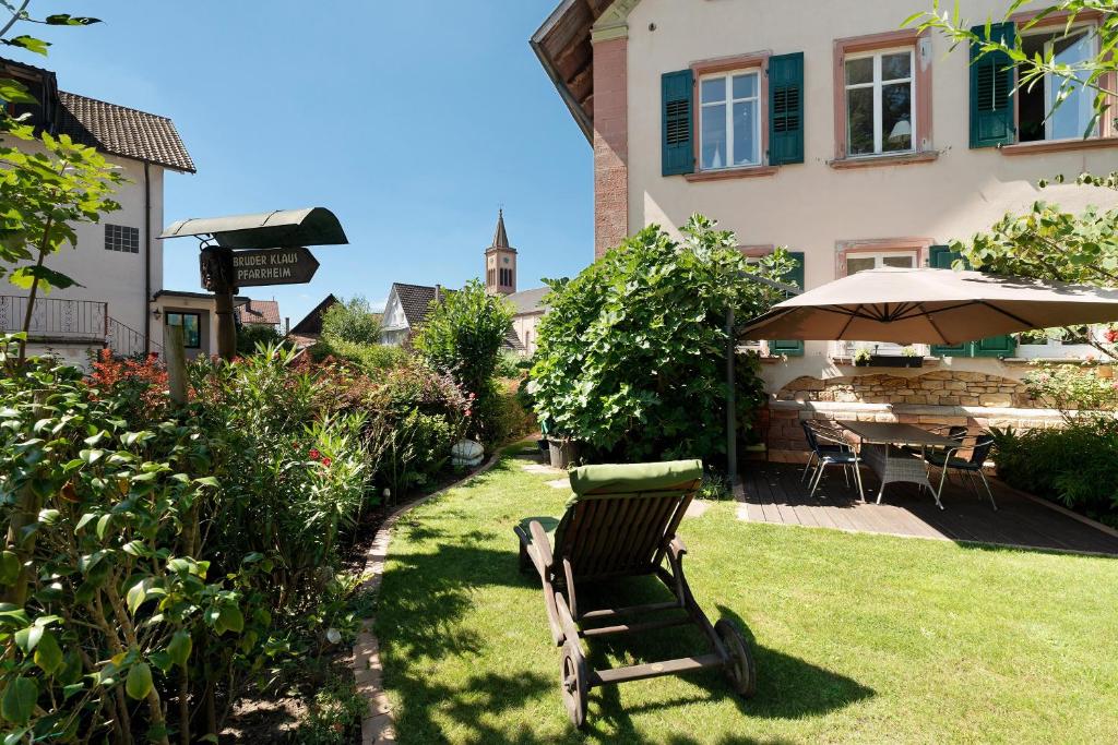 a yard with a chair and an umbrella at Schlafen im historischen Haus in Weier