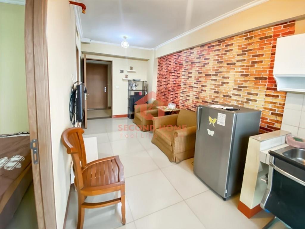 a living room with a brick wall at Cozy 2BR Bintaro Park View Pool in Jakarta