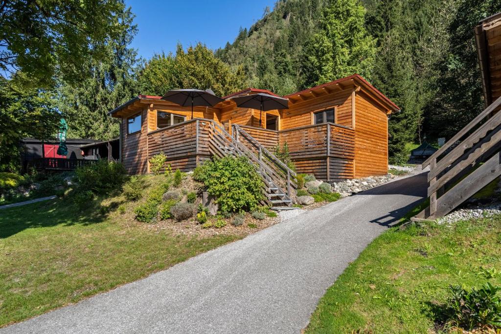 a log cabin with an umbrella on the side of a road at Alpenchalet zum Hirsch in Aschau