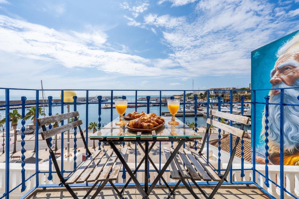 a table with a bowl of bread and two glasses of orange juice at Loft Jb in L'Ametlla de Mar