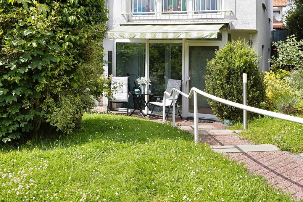 a house with a lawn with a table and chairs at Ferienwohnung an der Dönche in Kassel