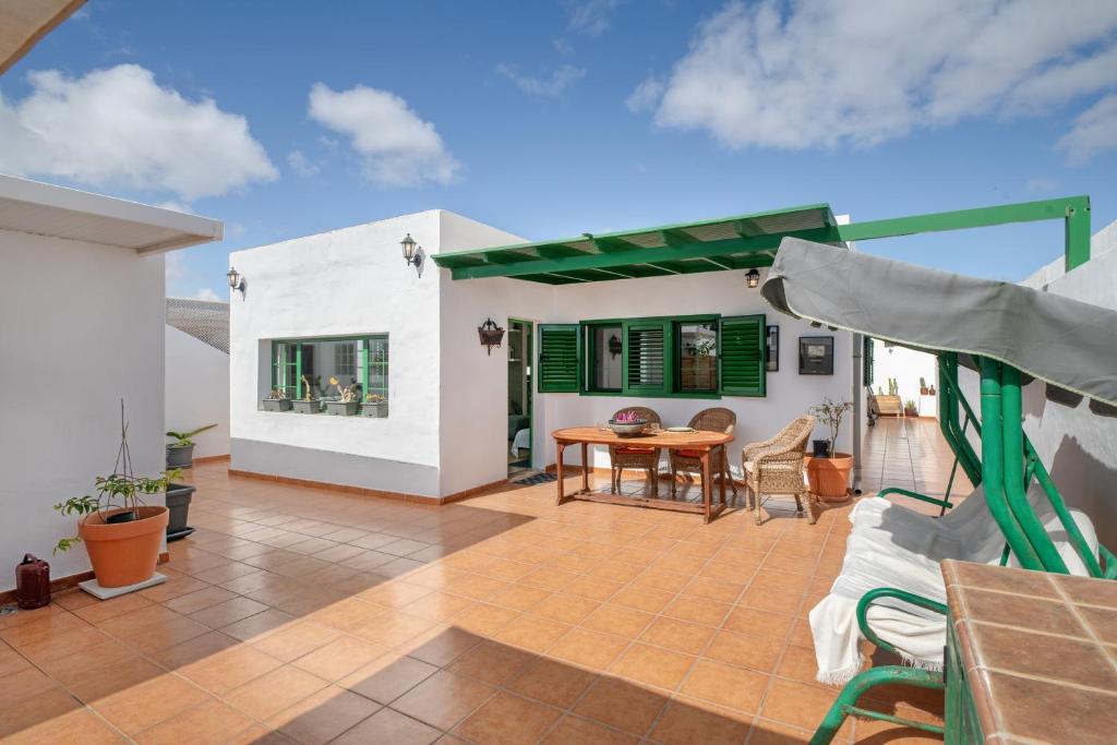 a patio with a table and chairs and a house at La Casa de Maika in Guatiza