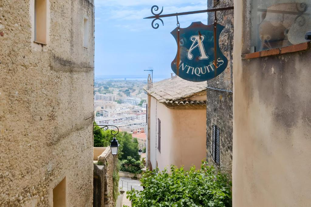 an alley with a sign on the side of a building at Le Grimaldi in Cagnes-sur-Mer