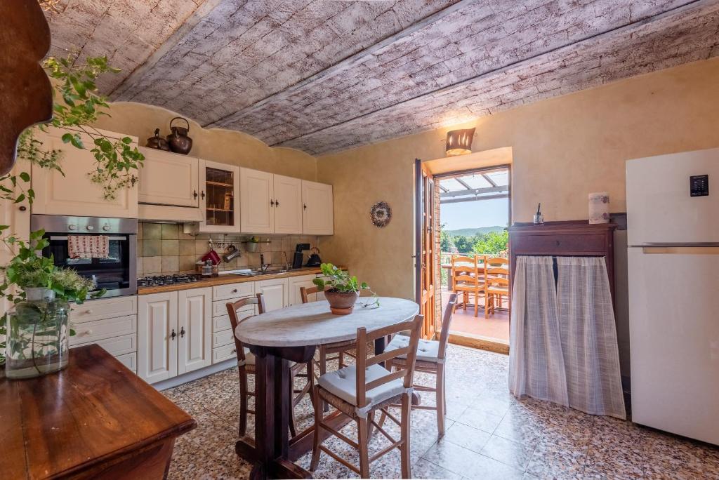 a kitchen with a table and a refrigerator at Podere La Speranza in Chiusdino