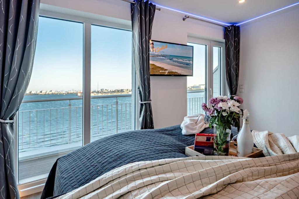 a bedroom with a bed and a large window at Schleivilla Kapitän James Cook2 in Kappeln