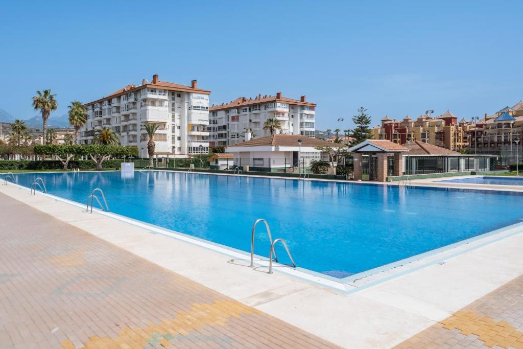 a large blue swimming pool with buildings in the background at Experiencia Marina A107 in Torrox