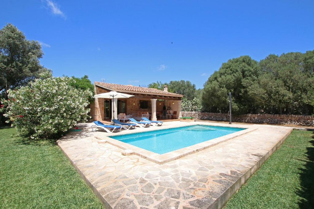 a villa with a swimming pool and a house at Ca Na Barbara in Santanyi