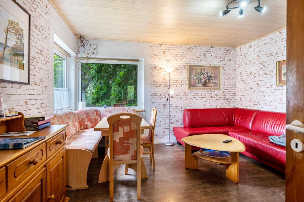 a living room with a red couch and a table at Ferienwohnung Caspersen in Viöl