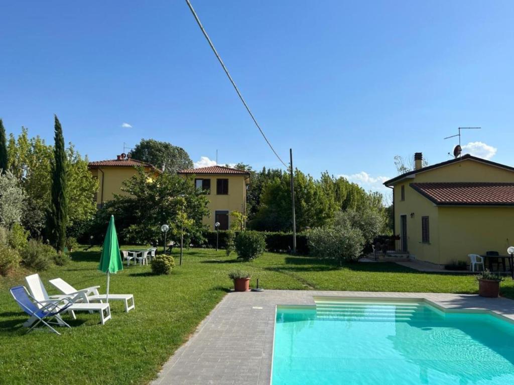 a backyard with a swimming pool and a house at Papà Giuseppe Il Fienile in Cortona