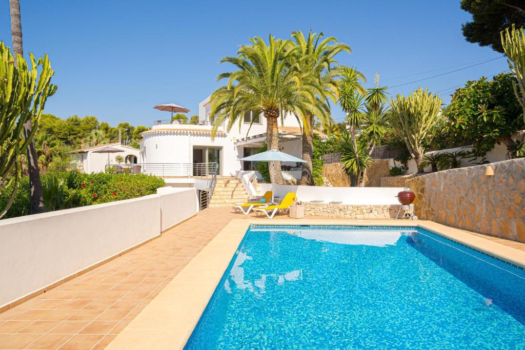 a swimming pool in front of a house at Casa Delfin in Moraira