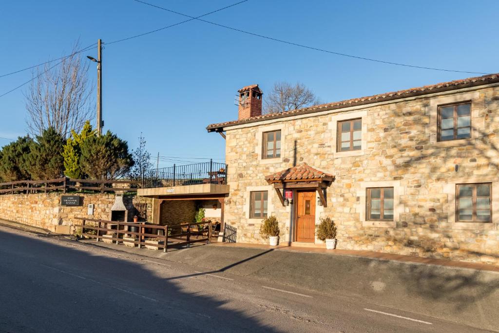 a stone building with a brown door on a street at Apartamento Juntana 1 in Villacarriedo