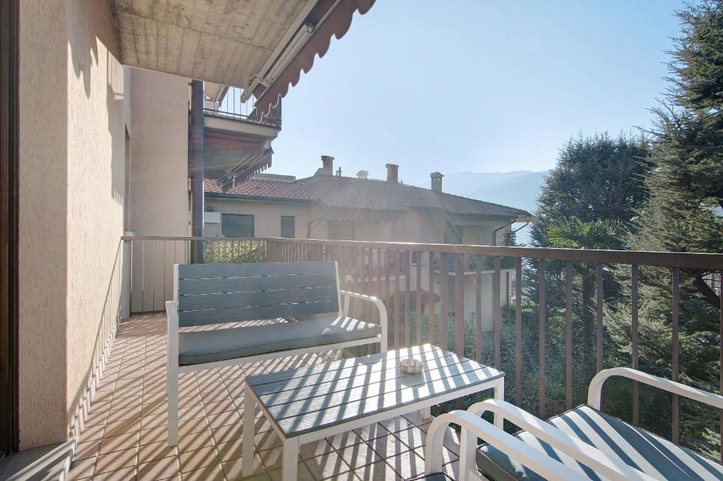 a blue bench and a table on a balcony at Casa Lierna in Lierna