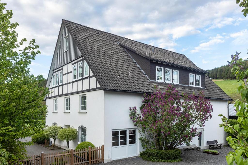 a white house with a black roof at Ferienhaus Weitblick in Eslohe