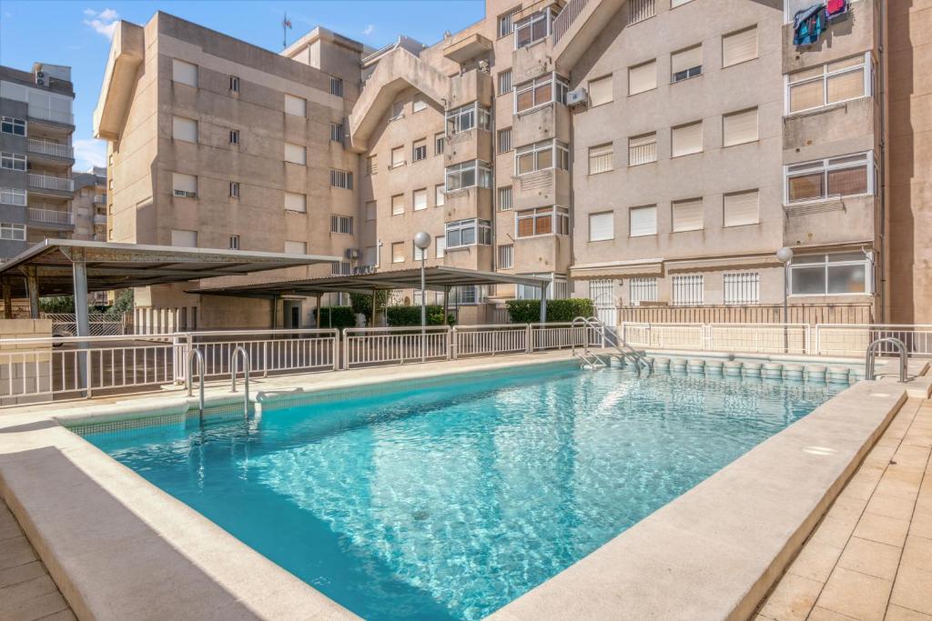 a large swimming pool in front of some buildings at Apartamento en playa de Daimús in Daimuz