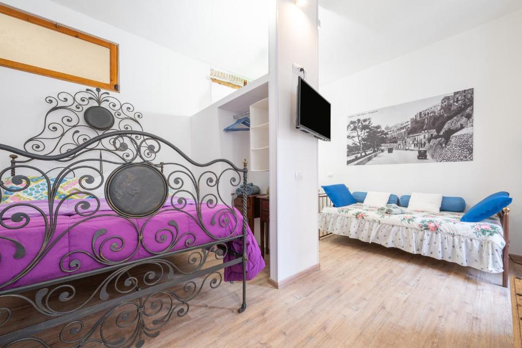 a room with a purple bed and a tv at Alla Marina Cagliari in Cagliari