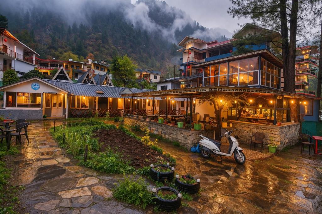 a building with a scooter parked in front of it at Giggling Goons Cabins & Kitchen in Kasol